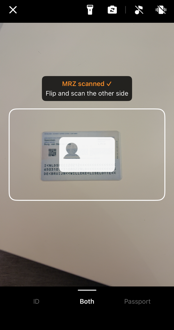 The MRZ Scanner asking the user to flip the document, with the animated flip prompt over the guide frame